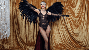 A glamorous Halloween costume featuring a sequined bodysuit, feathered wings, and sparkling crystal accessories, displayed against a luxurious velvet background.