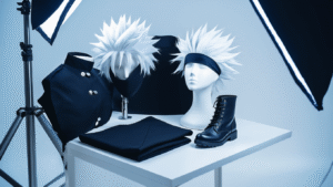 Gojo cosplay essentials including a white spiky wig on a mannequin, a black high-collar uniform, sleek black boots, and a blindfold, arranged on a clean white surface with dramatic studio lighting and subtle blue undertones.