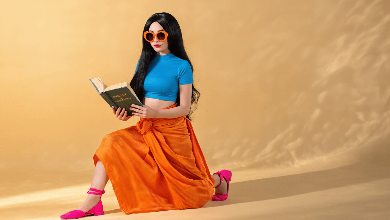 A confident woman in Nico Robin cosplay wears a blue cropped top and orange sarong, holding an archaeology book, with long black hair, pink shoes, and sunglasses, set against a warm golden hour backdrop.