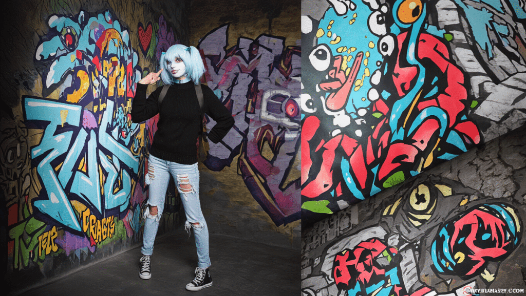 A person in a white prosthetic mask resembling Sally from a video game, wearing a blue pigtail wig, a black sweater, and ripped red jeans, posed against a clean background.