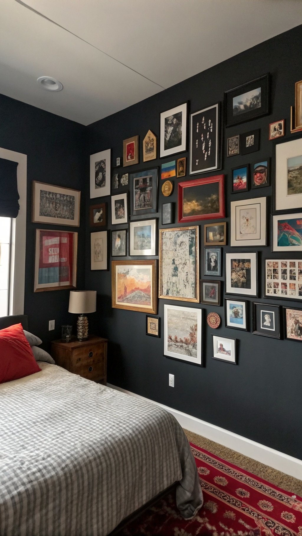 A dark boho bedroom featuring a gallery wall filled with various framed artworks and photographs.